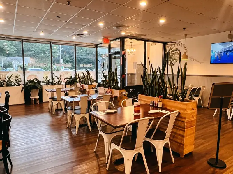 Sunlit dining room with booths and large storefront windows
