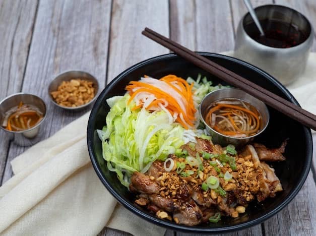 Grilled pork vermicelli bowl with fresh herbs and peanuts
